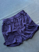 The His & Hers Silk Bottoms - Boxers by Rimmba | Sustainable Clothing are unisex, featuring an elastic waistband, and are displayed on a textured blue background to highlight the luxurious sheen of natural dye silk.