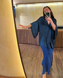 Karunia Fischer's taking a mirror selfie indoors. She wearing Mulberry silk skirt indigo with elegant kimono indigo. Her long, straight hair falls naturally over her shoulers.