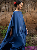 Indigo blue mulberry silk kaftan with white vertical line detail, wide draped sleeves, and flowing movement, handcrafted botanical-dyed maxi dress for sustainable luxury resort and coastal style