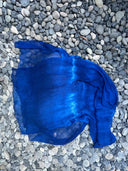 The Deep Blue - Indigo silk scarf by Rimmba | Sustainable Clothing, crafted from mulberry silk and plant-dyed, features indigo hues with a lighter blue center band and is displayed on smooth gray pebbles.