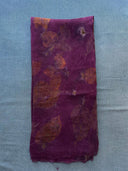 The Eco-Print Silk Chiffon Scarf - Magenta Purple by Rimmba | Sustainable Clothing features delicate orange-brown botanical prints, folded elegantly on a light blue textured surface to highlight its eco-printing craftsmanship.