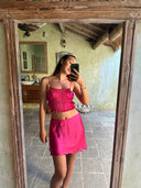 A woman takes a mirror selfie in a rustic room, wearing a vibrant Frida Crinkle Crop-Top and matching skirt by Rimmba | Sustainable Clothing, reflecting her commitment to the Zero Waste Program.