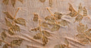 a piece of light, semi-transparent fabric with a botanical leaf print pattern.
The leaves appear in natural shades of green and brown, arranged in an organic, scattered design.
The fabric has a soft texture with visible creases, suggesting it might be hand-dyed or eco-printed using natural leaves and pigments.