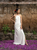 Barefoot woman wearing a Mulberry silk halter maxi dress in white. Hancrafted botanical dyed maxi dress for sustainable fashion for bridal and resort wear.
