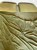 A neatly made bed features the Mint Green - Full Silk Bedding Set by Rimmba | Sustainable Clothing, with two matching pillows. The slightly rumpled blanket reveals circular stitched patterns in a daylight-filled room.