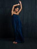 Side view of flowy silk maxy dress indigo wtih thin straps and gathered bust detail. Luxury fashion for bridal, formal, and resort wear.