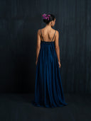 Back side view of woman wearing maxy silk dress indigo with thin straps and gathered bust detail. luxury fashion for bridal, formal, and resort wear.