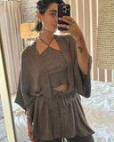 A woman with short hair standing take a mirror selfie wearring Mud-dye Silk halter top with matching kimono and pants. 