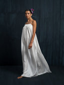 Side view of ivory white mulberry silk maxi dress with thin straps and flowing drape, handcrafted sustainable luxury gown for weddings, evening events, and resort occasions