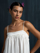 Close-up of ivory white mulberry silk maxi dress with delicate thin straps and gathered bust detail, handcrafted sustainable luxury gown for weddings, evening, and resort wear
