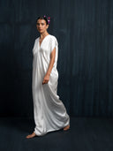 Ivory white mulberry silk kaftan in walking motion, handcrafted luxury maxi dress with deep V-neck, eco-friendly botanical dye, perfect for sustainable bridal and resort fashion

