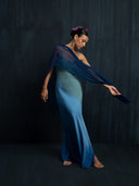 Barefoot woman wearing an ombre green indigo maxy dress and indigo scarf. Luxury fashion for bridal, formal, and resort wear.