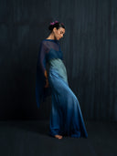 Right side view of woman wearing a luxury ombre silk maxy dress and indigo silkchiffon scarf. Luxury fashion for bridal, formal< and resort wear.