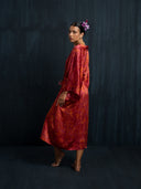 Side view of woman wearing Mulberry silk kimono Red ecoprint against a dark background.