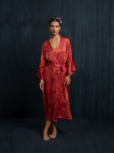 A woman wearing Mulberry silk kimono red ecoprint with belt. Hancrafted botanical dyed kimono for sustainable luxury fashion and resort wear.