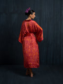 Back view of woman wearing Mulberry silk kimono red ecoprint with belt. Hancrafted botanical dyed kimono for sustainable luxury fashion and resort wear.