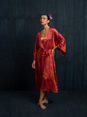 Barefoot woman wearing a Mulberry silk kimono red ecoprint and mira silk dress red ecoprint. Hancrafted botanical dyed kimono for sustainable fashion and resort wear.