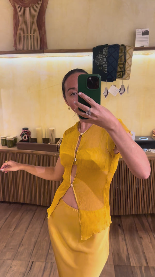 Karunia Fischer's standing a mirror selfie wearing silk chiffon marigold top and silksatin marigold skirt. 